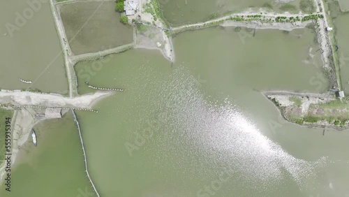 water flowing into thepond. aerial top Uncolor grade, Hlg  Raw video footage, Pankhali, sathkhira, Bangladesh photo