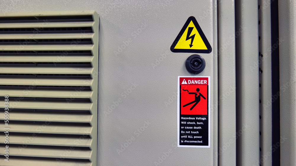 Concepts for work and workplace safety. Electric shock warning indicators mounted to the electric control cabinet warn of danger. Caution: use extreme caution when servicing electrical equipment Concepts for work and workplace safety. Electric shock warning indicators mounted to the electric control cabinet warn of danger. Caution: use extreme caution when servicing electrical equipment