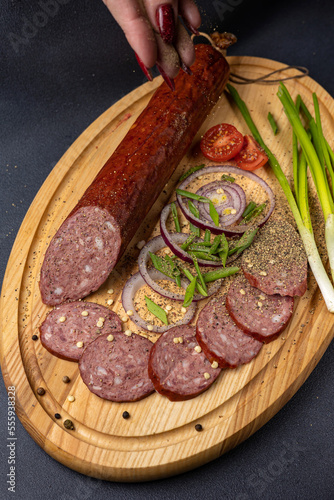 Traditional meat delicacies, sausages on a dark table 