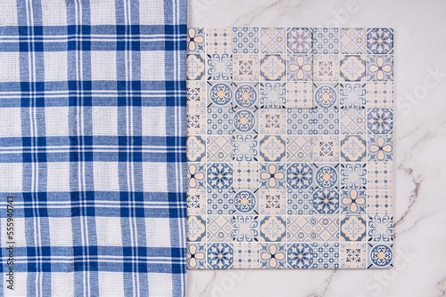 blue patterned tile with blue and white checkered cloth on marble background photo