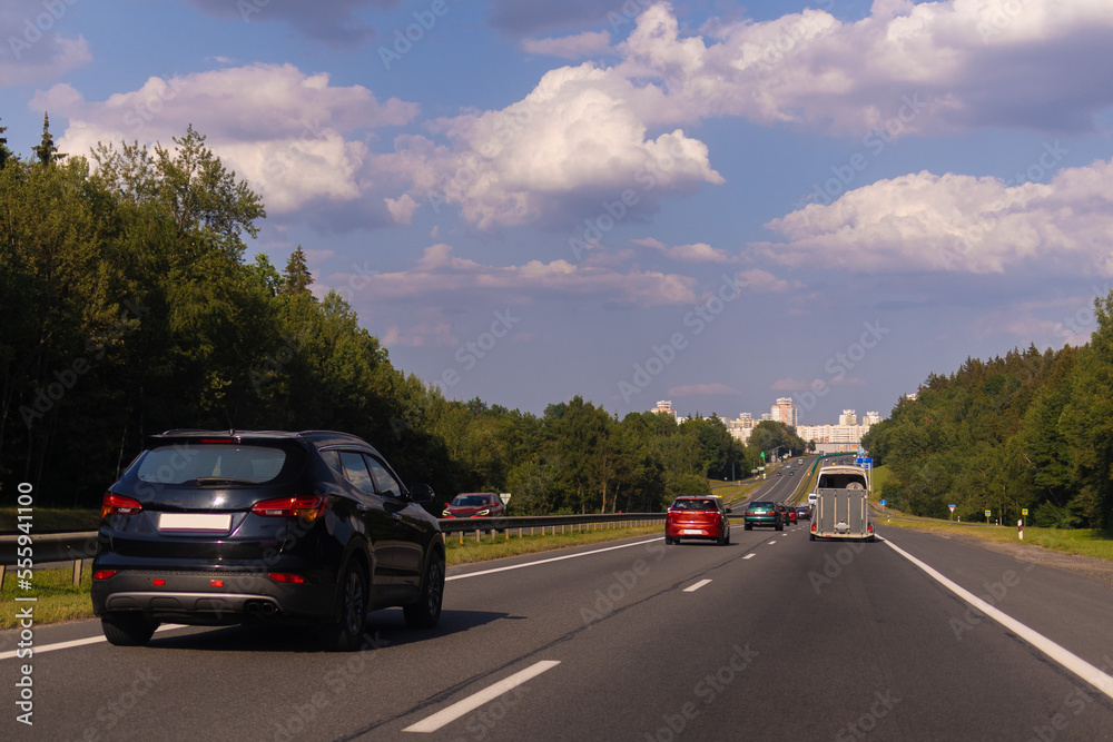 Highway wide road in the city, transport and blue sky with clouds on a summer day Highway wide road in the city, transport and blue sky with clouds on a summer day