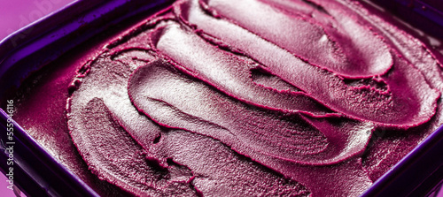 Creamy açaí pot over purple surface. photo