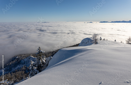 Winter mountains covered with snow landscape over clouds