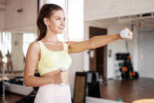 A sporty woman with a slim body trains at a fitness club. Healthy lifestyle concept.