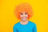 Girls birthday party. Funny kid in curly redhead wig. Time to have fun. Teen girl with orange hair, being a clown. Happy teenager portrait. Smiling girl.