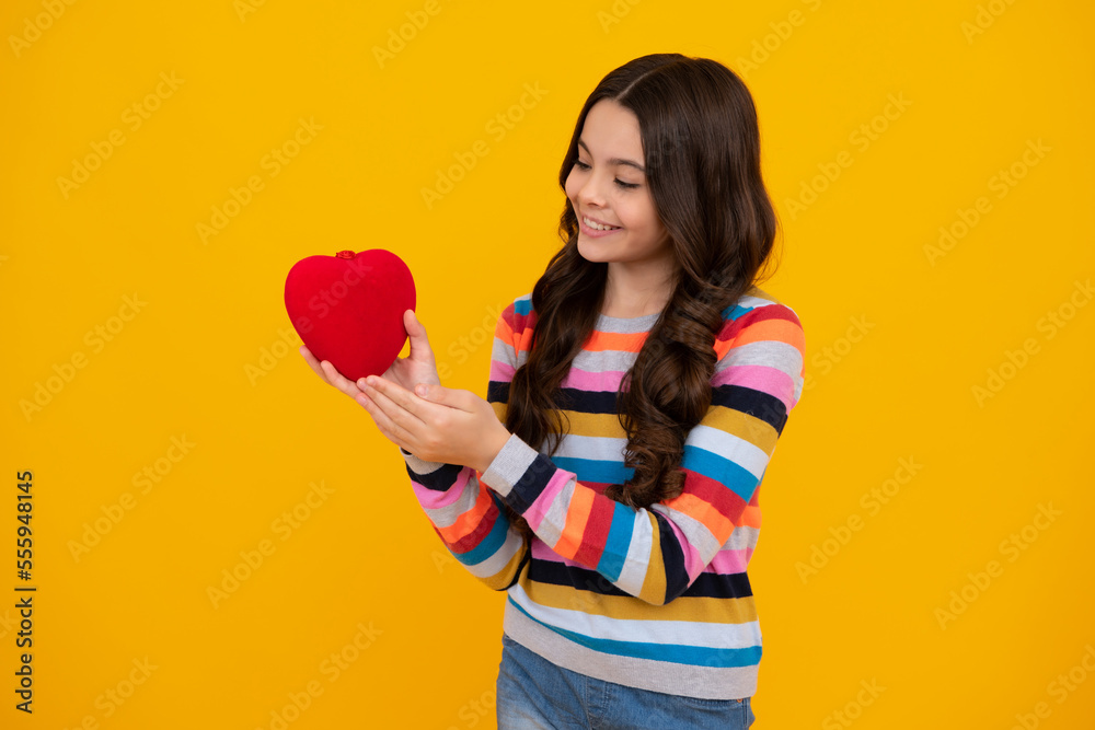 Lovely child teen girl with shape heart love holiday and valentine symbol. Valentine or birthday day. Gift heart present. Happy teenager, positive and smiling emotions of teen girl. Lovely child teen girl with shape heart love holiday and valentine symbol. Valentine or birthday day. Gift heart present. Happy teenager, positive and smiling emotions of teen girl.