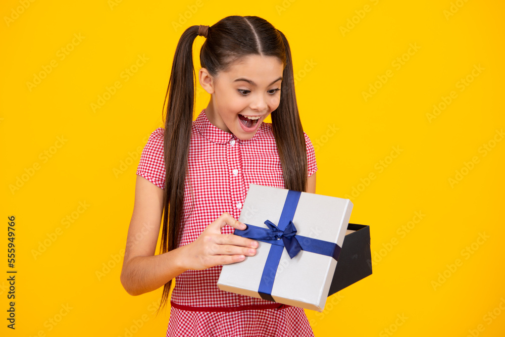 Teenager child with gift box. Present for holidays. Happy birthday, Valentines day, New Year or Christmas. Kid hold present box. Happy teenage girl, positive and smiling emotions.
