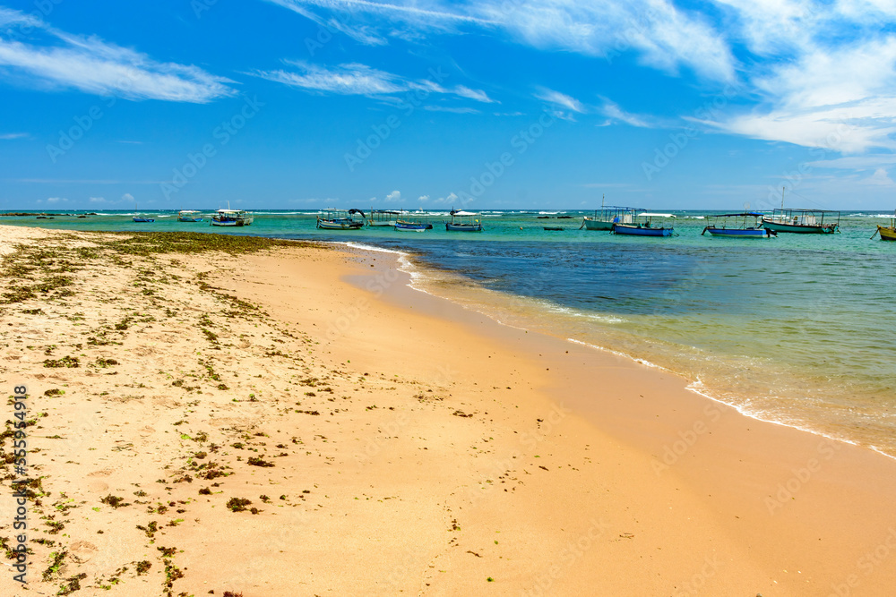 Boats on the transparent waters of Itapua beach in the city of Salvador in Bahia on a sunny day