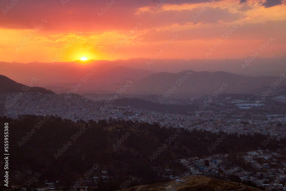 red sunset with city in the background, and mountains in foreground, sierra de guadalupe in state of mexico and mexico city