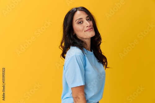 Woman signal smile with teeth emotion portrait in blue t-shirt on yellow background, hands up, surprise, lifestyle, copy space