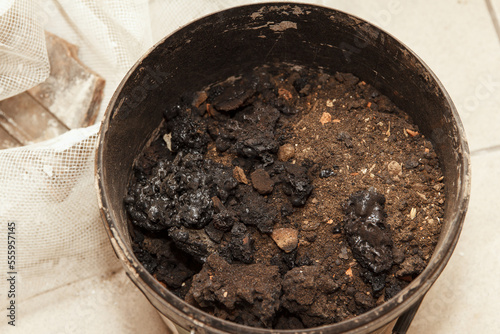 Ash cleaning, a combustion product that remains in stoves from burning firewood and coal. Garbage, which was collected in a bucket, after cleaning the stove photo