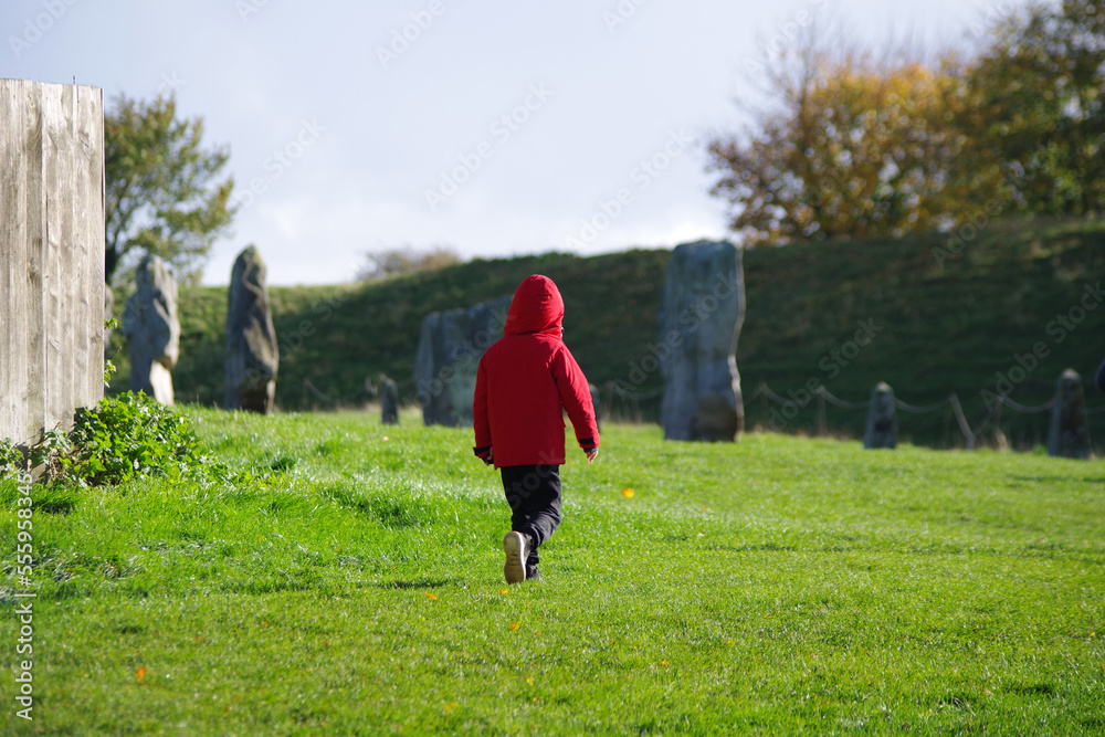 Jeune enfant jouant entre les pierres d'Avebury Circle Jeune enfant jouant entre les pierres d'Avebury Circle