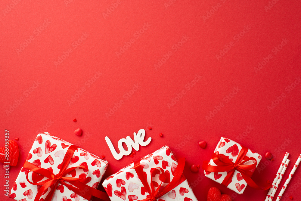 Valentine's Day concept. Top view photo of present boxes inscription love heart shaped candle straws and sprinkles on isolated red background with copyspace Valentine's Day concept. Top view photo of present boxes inscription love heart shaped candle straws and sprinkles on isolated red background with copyspace