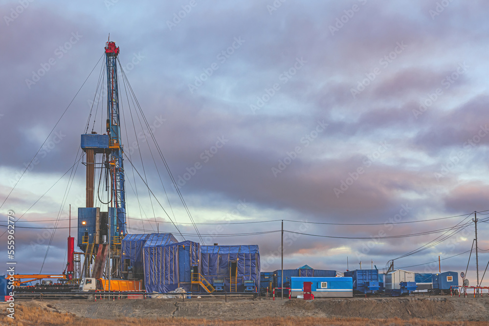 Infrastructure for drilling oil and gas wells in the Far North in the Arctic zone of Russia. Autumn. In the foreground is the vegetation of the polar tundra. Beautiful sky