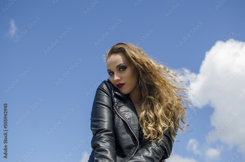 Curly blond hair woman outdoors sky background