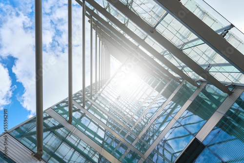 Teil der Glasfassade an einem modernen Bürogebäude in der Innenstadt von Berlin bei blendendem Sonnenlicht