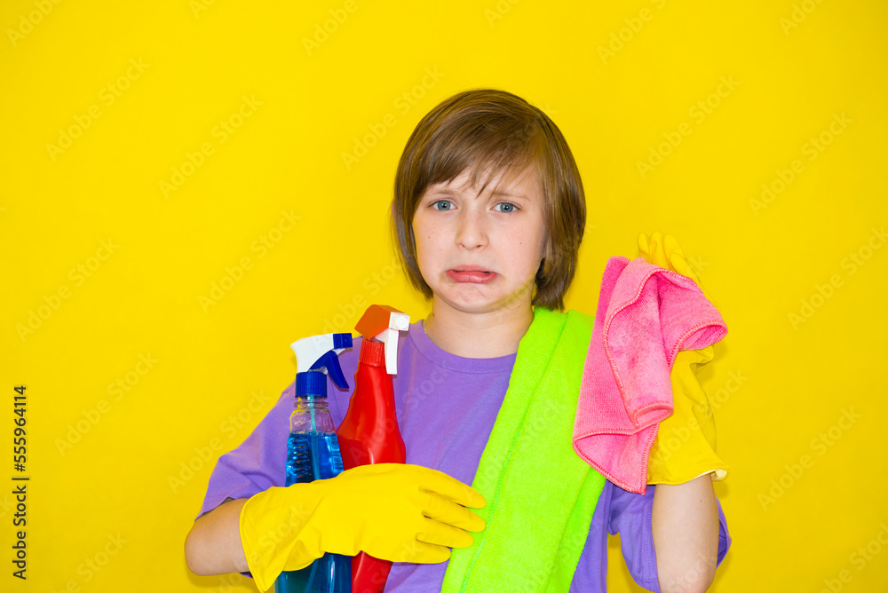 upset boy, child, schoolboy, put on rubber gloves, holds rags for cleaning in his hands, does not want to clean up upset boy, child, schoolboy, put on rubber gloves, holds rags for cleaning in his hands, does not want to clean up
