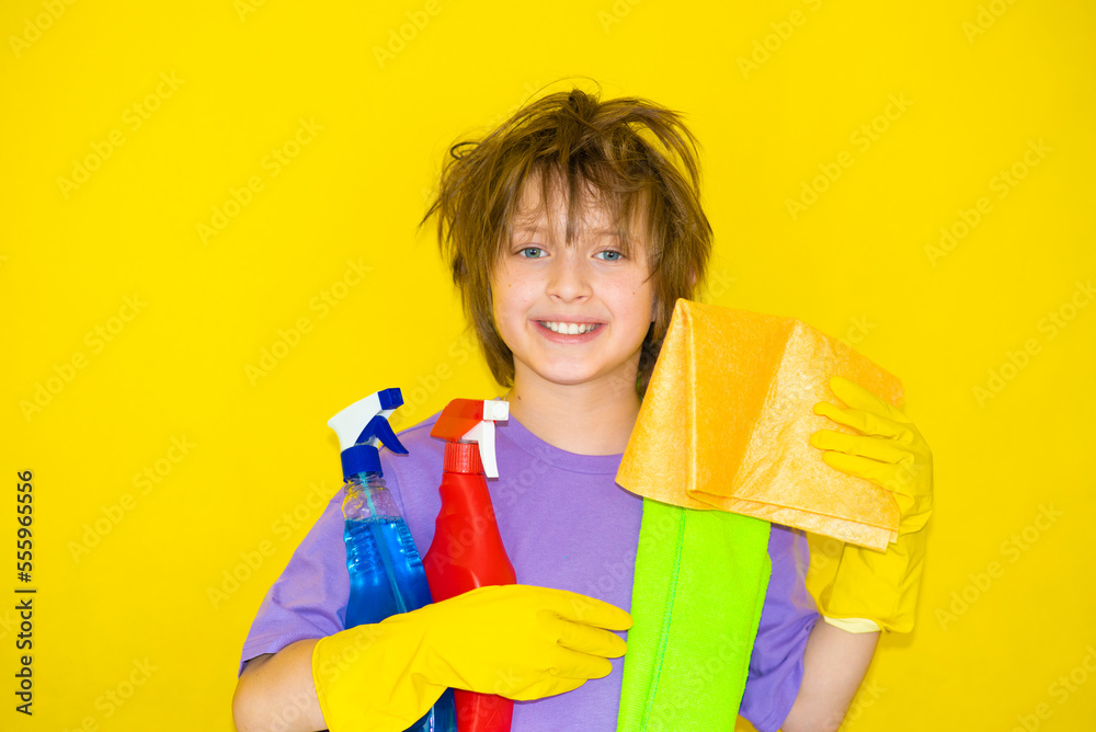 happy boy with shaggy hair holding cleaning products and rags happy boy with shaggy hair holding cleaning products and rags