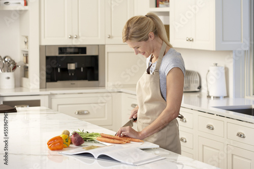 Woman Reading Cookbook in Kitchen photo