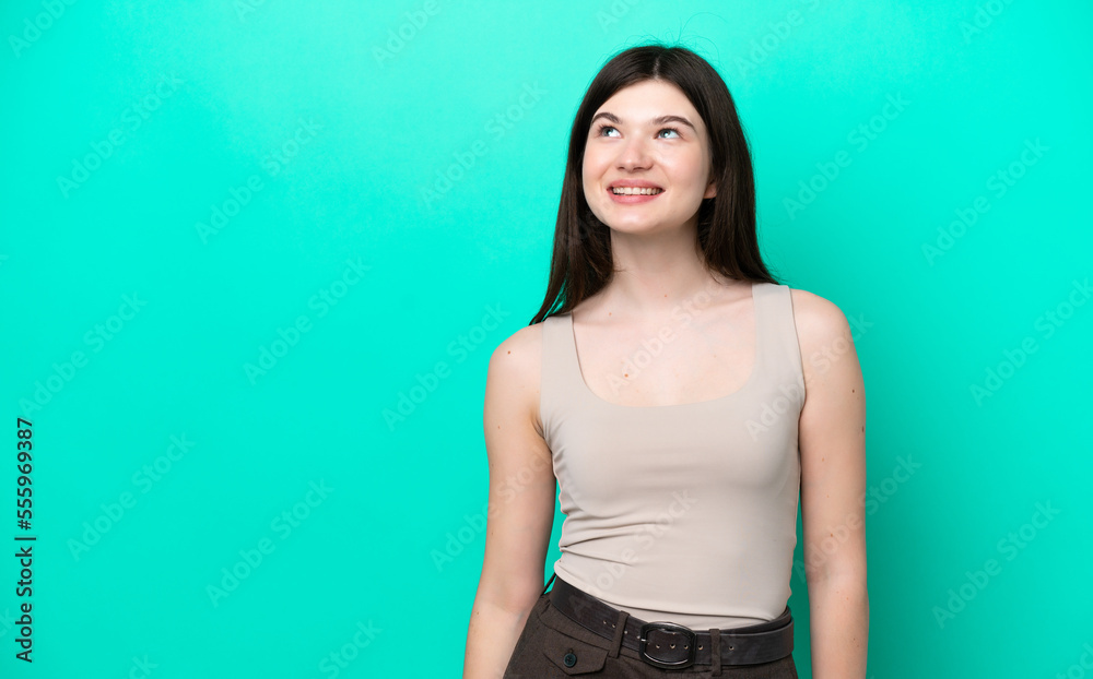 Young Russian woman isolated on green background thinking an idea while looking up Young Russian woman isolated on green background thinking an idea while looking up