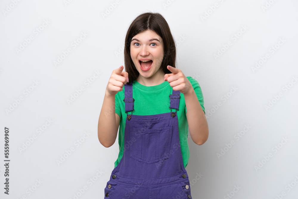 Young Russian woman isolated on blue background surprised and pointing front Young Russian woman isolated on blue background surprised and pointing front