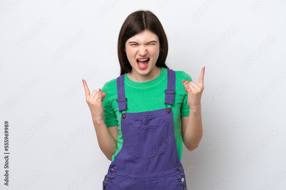 Young Russian woman isolated on blue background making horn gesture