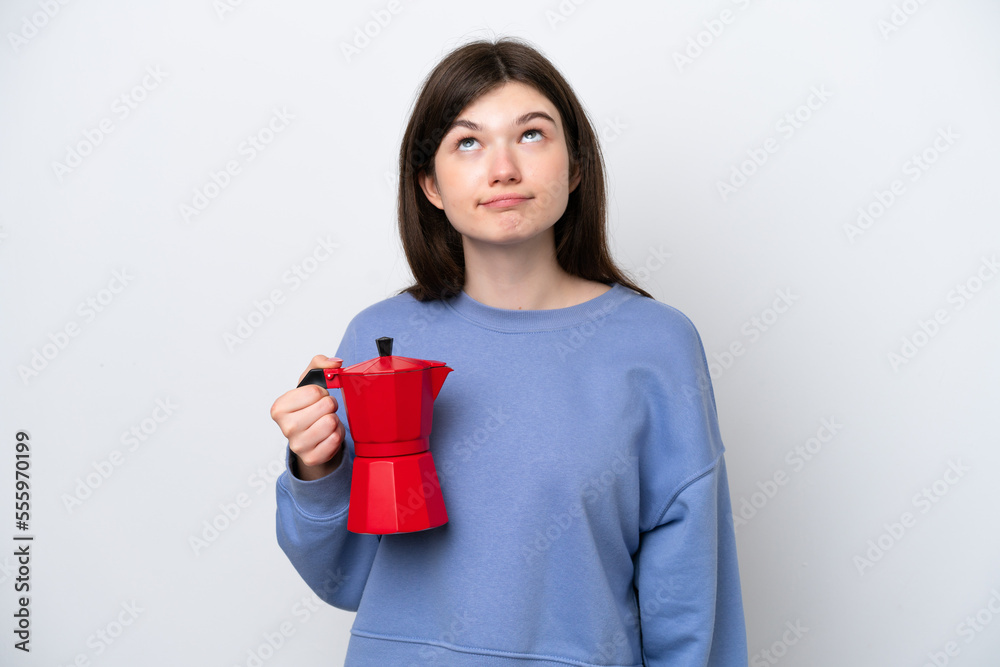 Young Russian woman holding coffee pot isolated on white background and looking up Young Russian woman holding coffee pot isolated on white background and looking up
