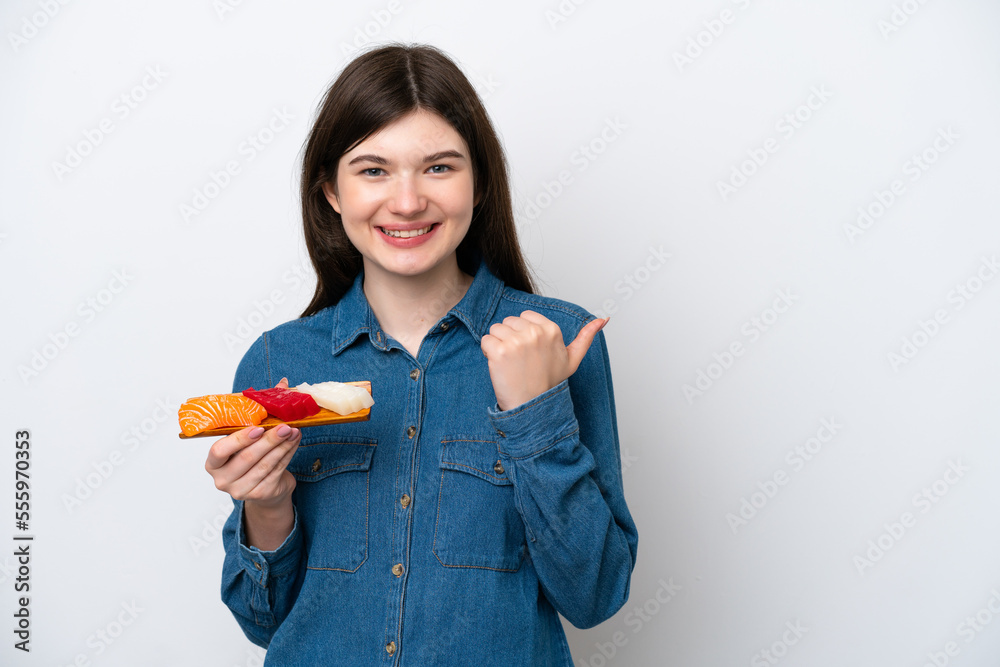 Young Russian woman holding sashimi isolated on white background pointing to the side to present a product Young Russian woman holding sashimi isolated on white background pointing to the side to present a product