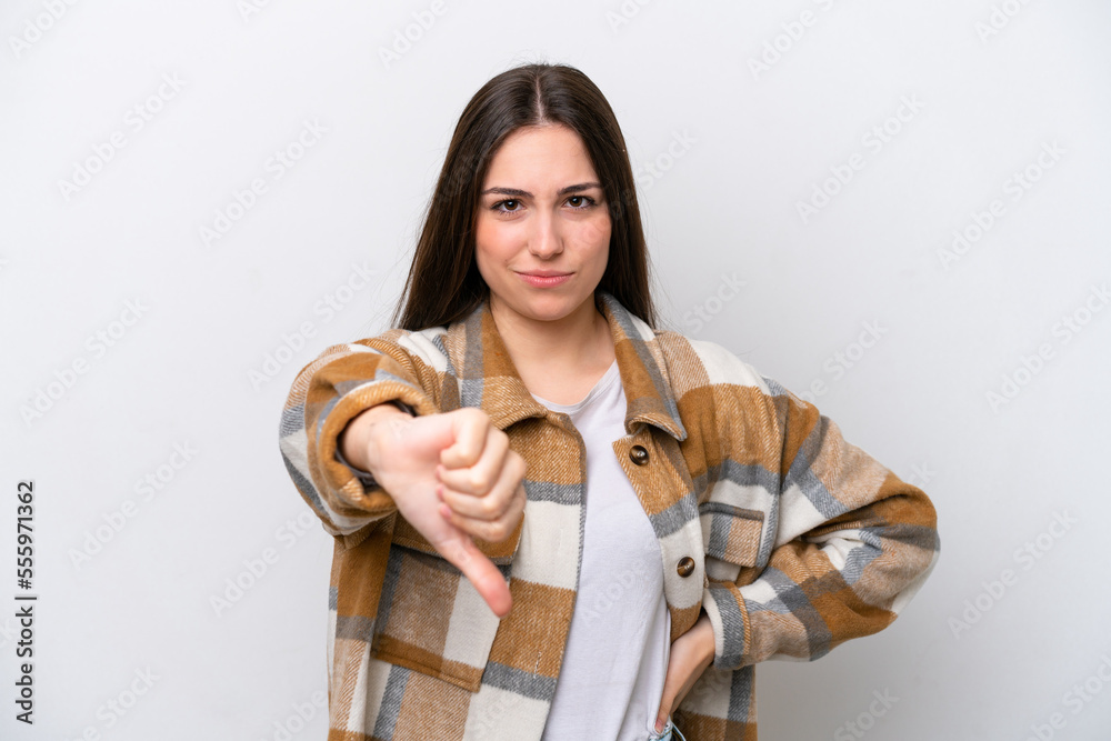 Young girl isolated on white background showing thumb down with negative expression Young girl isolated on white background showing thumb down with negative expression