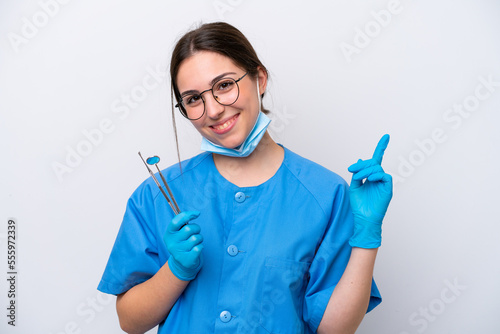 Dentist caucasian woman holding tools isolated on white background showing and lifting a finger in sign of the best