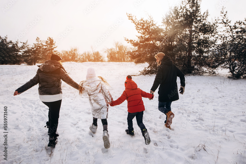 Father, mother and two children daughters are having fun and playing on
