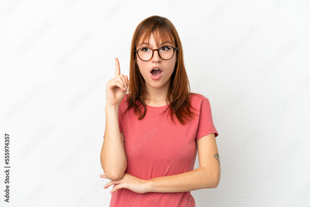 Redhead girl isolated on white background thinking an idea pointing the finger up Redhead girl isolated on white background thinking an idea pointing the finger up