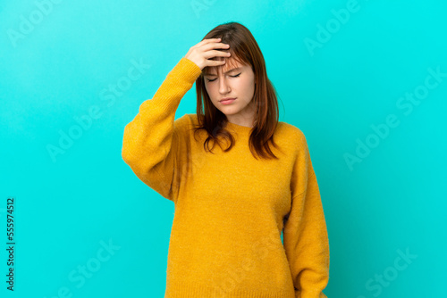 Redhead girl isolated on blue background with headache © luismolinero