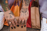 Mulher tatuada segurando diversas caixas para presente