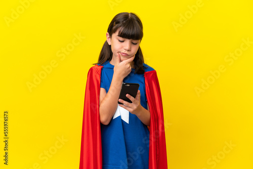 Little super hero kid isolated on purple background thinking and sending a message