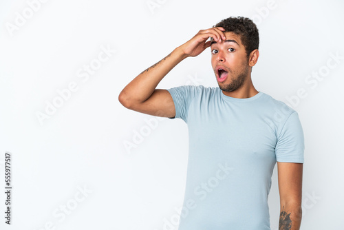 Young handsome Brazilian man isolated on white background doing surprise gesture while looking to the side