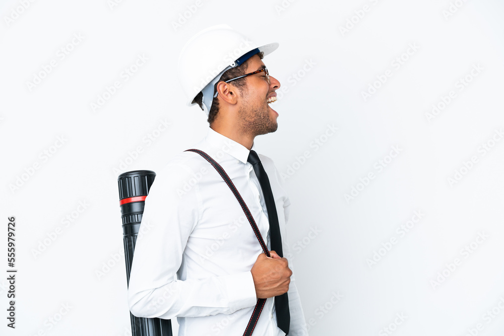 Architect brazilian man with helmet and holding blueprints laughing in lateral position Architect brazilian man with helmet and holding blueprints laughing in lateral position