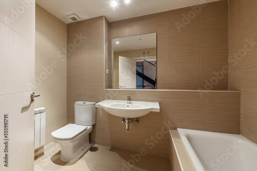Bathroom with white porcelain sink without cabinet  built-in shelf  square frameless mirror and porcelain bathtub