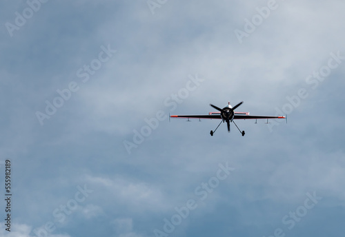 a plane flying head-on over a blue sky with white clouds. concept loneliness