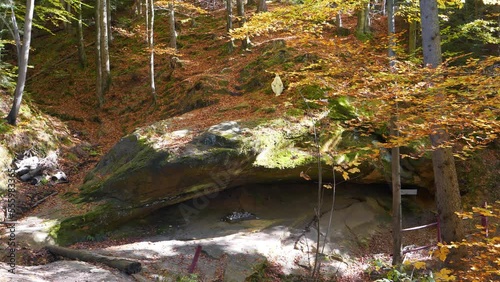 Blessed Stone and sacred spring in the forest near Manyava Skete in Western Ukraine, regarded as a place of prayer and of spiritual purification. Spring of healing water emits from underneath it photo