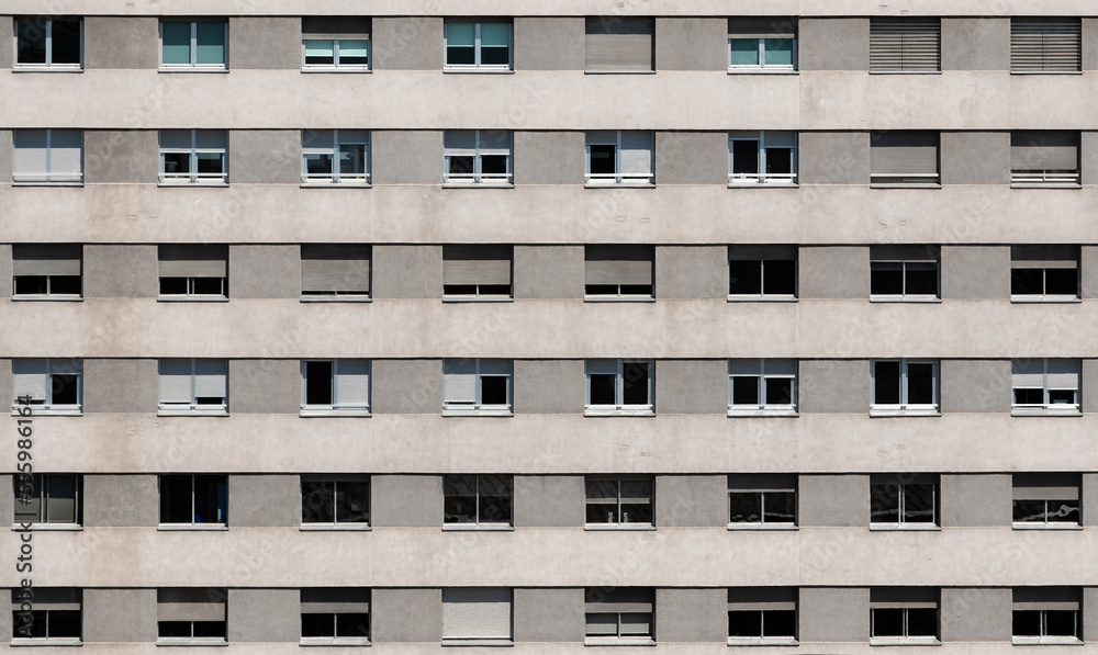 Building facade in gray tones with a geometric pattern of windows with shutters Building facade in gray tones with a geometric pattern of windows with shutters