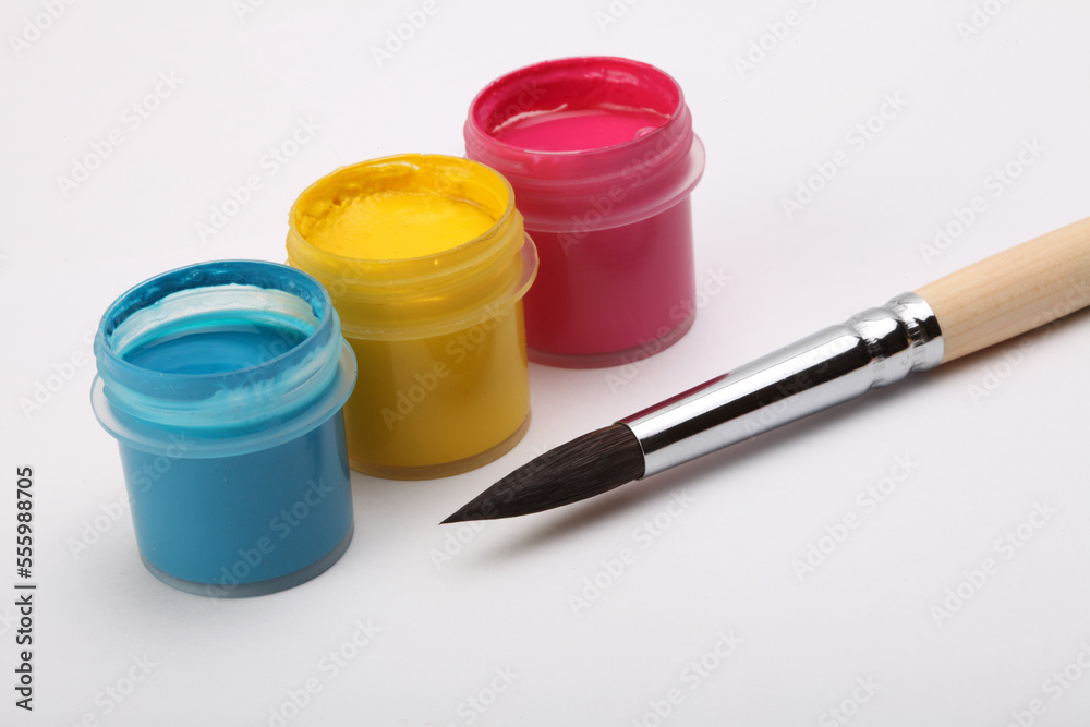 Acrylic paints in boxes, brushes on white background. Acrylic paints in boxes, brushes on white background.