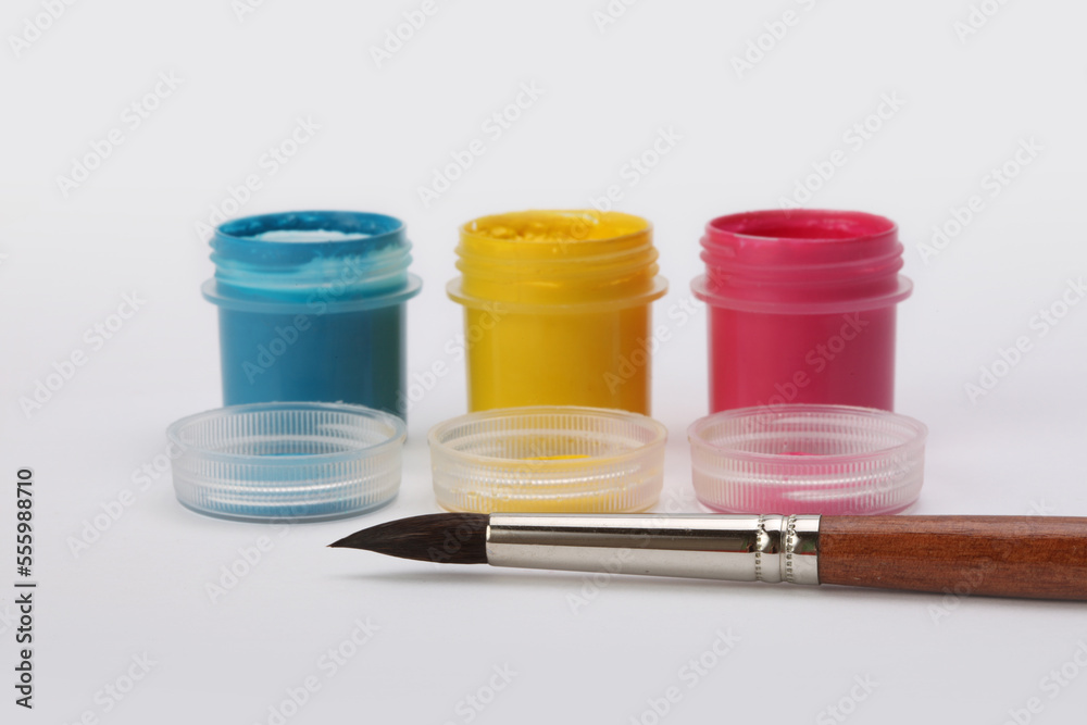 Acrylic paints in boxes, brushes on white background. Acrylic paints in boxes, brushes on white background.