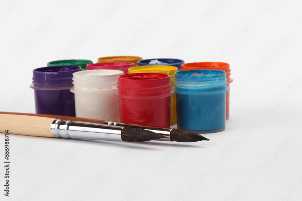 Acrylic paints in boxes, brushes on white background. Acrylic paints in boxes, brushes on white background.