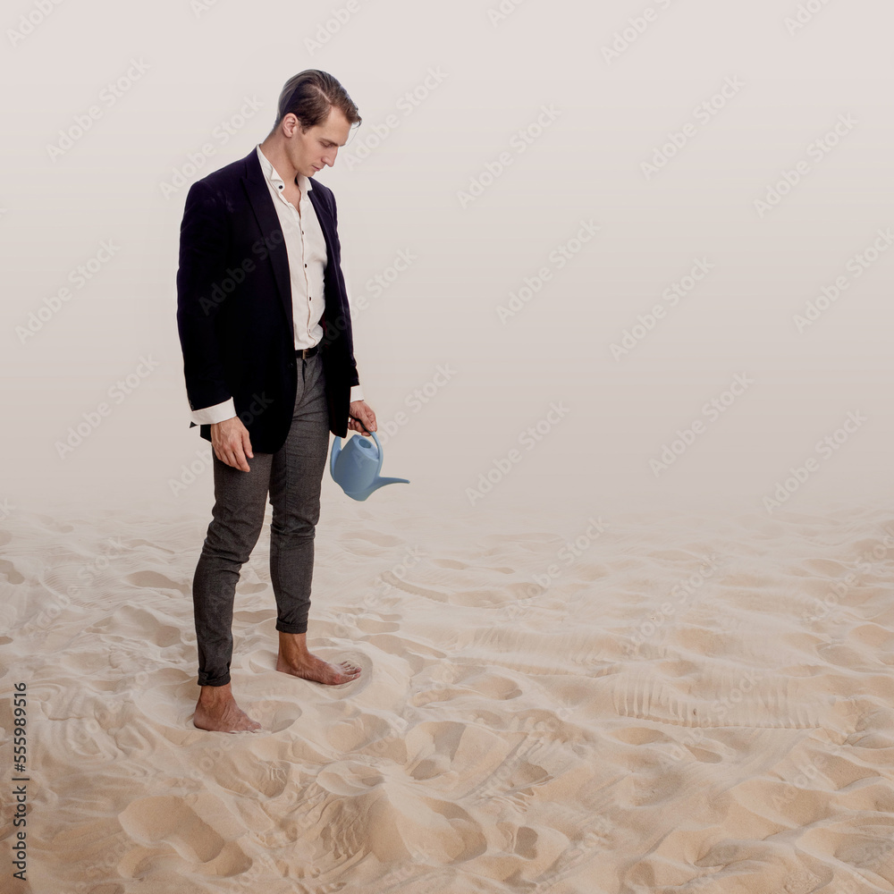 The global economic crisis, the concept of risky investments. A businessman financier with a watering can in his hands stands in the desert, a gardener fertilizes the soil where nothing grows The global economic crisis, the concept of risky investments. A businessman financier with a watering can in his hands stands in the desert, a gardener fertilizes the soil where nothing grows