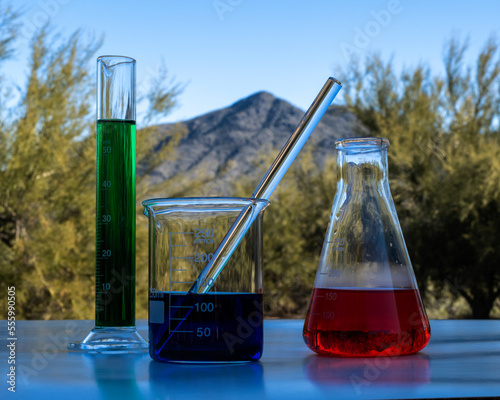 Принти на полотні Chemicals glass containers outside in front of a mountain