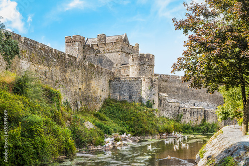Tall ramparts, towers and moat of the medieval historic Cahir castle, Ireland photo