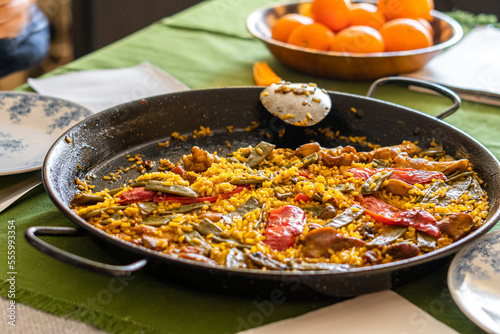 Paella on the table at home, food to gather family and friends