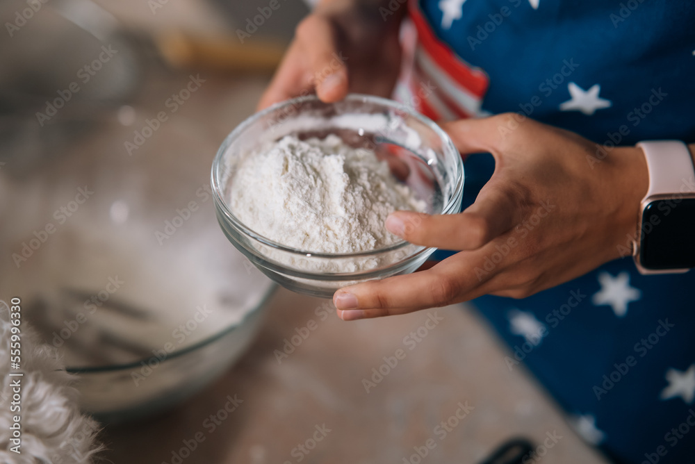 Close-up of female hands holding flour in a bowl. Close-up of female hands holding flour in a bowl.