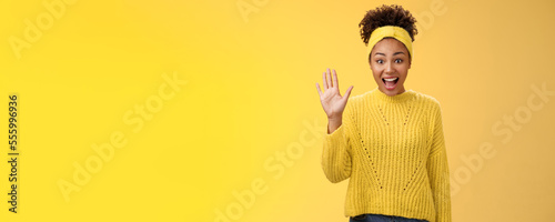Friendly outgoing excited cute millennial female coworker newbie greeting team waving palm hi hello gesture energized get know new people welcoming greeting friends, standing yellow background
